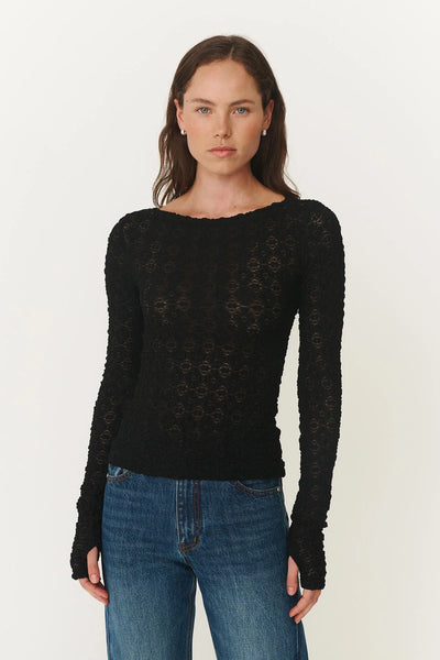 Model wearing the Noir Samantha top, showcasing the body-skimming "second-skin" fit and the elegant transparency of the floral lace.