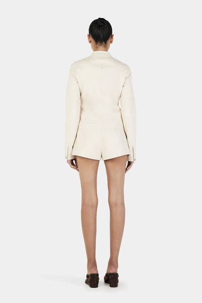 Back view of the Tari jacket illustrating the clean princess seams and the high-quality finish of the cream PU leather.