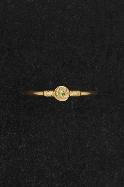 Flat-lay view of the Temple of the Sun Bia Ring in 18k Gold Vermeil, showing the round green tsavorite center and textured detailing against a dark backdrop.