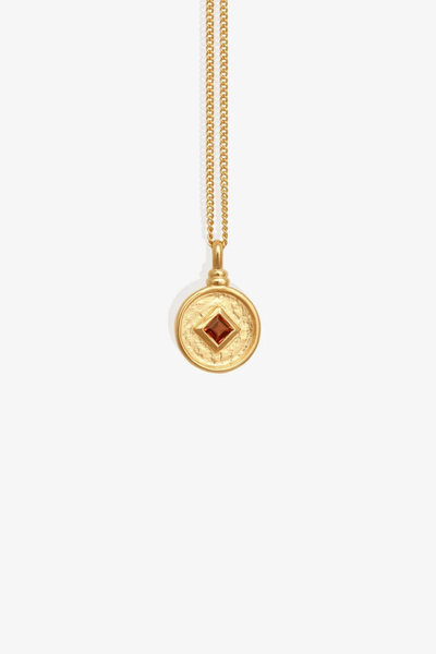 Studio product shot of the Temple of the Sun Blaze Coin Necklace in 18k Gold Vermeil featuring a round brushed coin pendant with a princess-cut orange garnet on a fine gold chain.