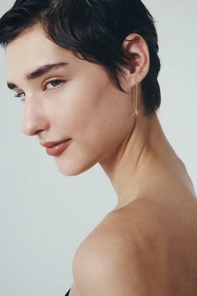 Three-quarter studio portrait of a model showcasing the length and motion of the Temple of the Sun 18k Gold Vermeil Electra Earrings.