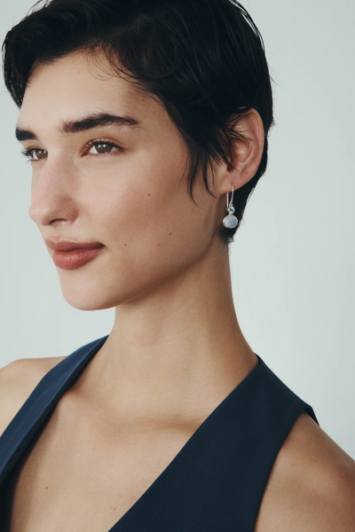 Profile view of a model wearing the Temple of the Sun Ether Earring in Sterling Silver.