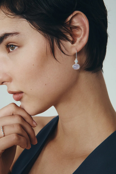 Close-up lifestyle view of a model wearing the Temple of the Sun Ether Earring in Sterling Silver resting her hand on her chin.