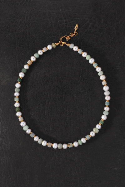 Flat-lay product shot of the complete Hydra Necklace laid out in a circle on a dark textured surface.