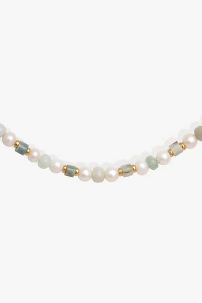 Studio product shot showcasing the green and golden Burmese jade and white pearl beaded strand of the Temple of the Sun Hydra Necklace.