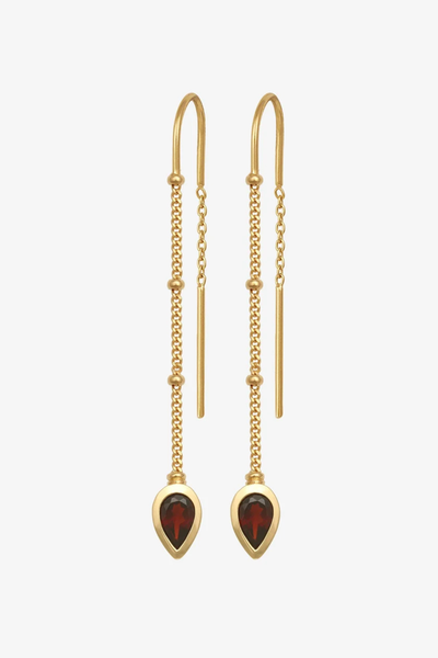 Studio product shot of the pair of Temple of the Sun Ignis Threader Earrings in 18k Gold Vermeil featuring delicate chain drops and pear-cut garnet settings against a white background.