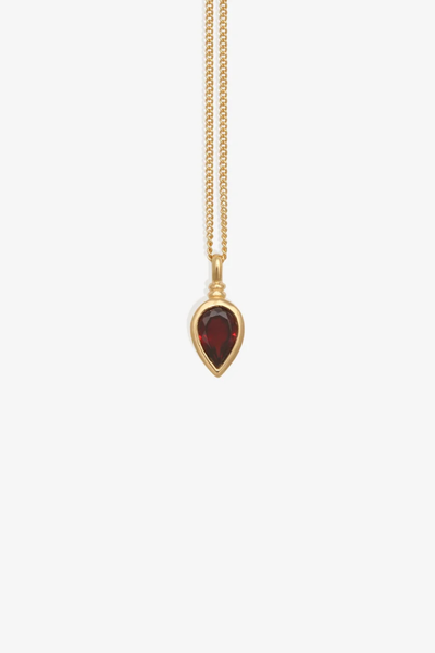 Studio product shot of the Temple of the Sun Ignis Necklace in 18k Gold Vermeil featuring a delicate fine chain and a bezel-set pear-cut garnet pendant against a clean white background.