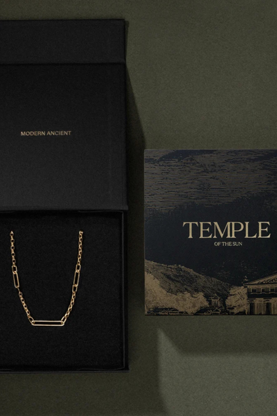 Top-down view of a black Temple of the Sun branded jewelry box and artwork card.
