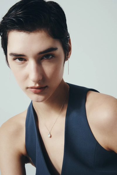 Frontal portrait photo of a model wearing the Sterling Silver Soma Coin Necklace looking towards the camera.