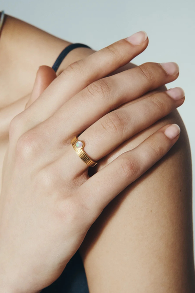 Close-up model shot showcasing the Temple of the Sun Soma Ring in 18k Gold Vermeil on a finger rested on a shoulder.