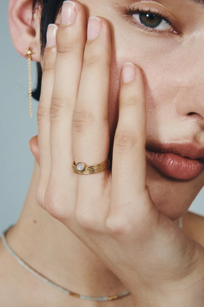 Portrait of a model resting her face against her hand, wearing the Temple of the Sun Soma Ring in 18k Gold Vermeil.