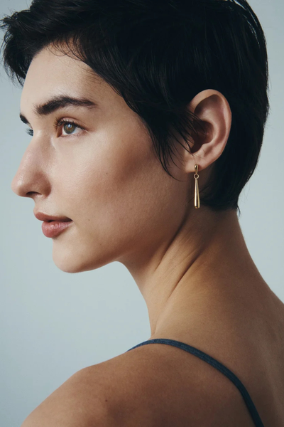 Side profile view of a model wearing the Temple of the Sun Stilla Earring in 18k Gold Vermeil.
