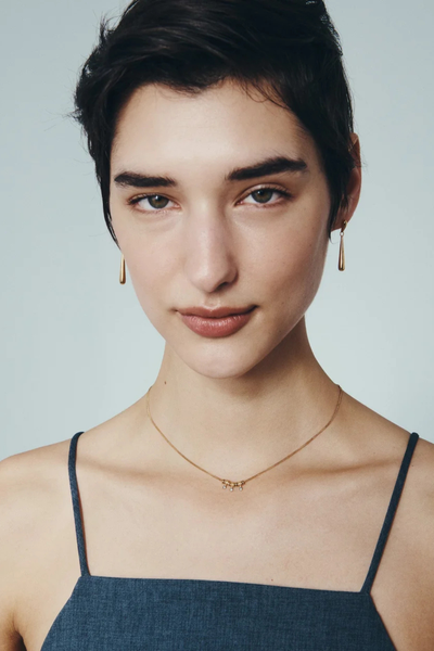 Frontal portrait of a model wearing the Stilla Earrings in 18k Gold Vermeil paired with a delicate gold drop necklace.