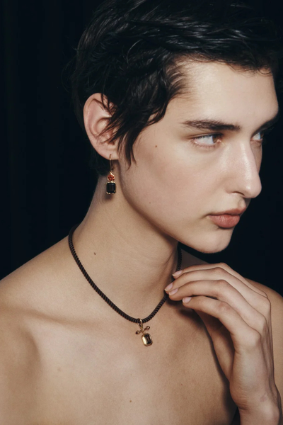 Side-profile photo of a model wearing the Temple of the Sun Umber Earring in 18k Gold Vermeil paired with a corded gemstone pendant necklace.
