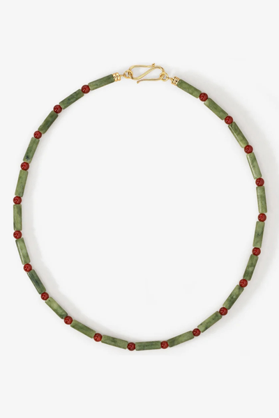 Studio product shot of the Temple of the Sun Vana Beaded Necklace featuring green serpentine jade tubes and red agate round beads with a gold S-hook clasp.