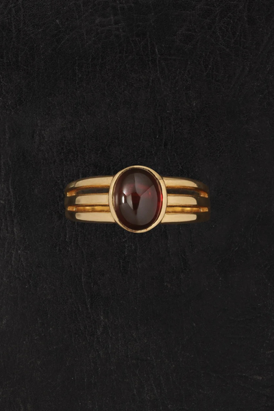 Overhead product display of the Vega Gold Vermeil Ring on a dark leather surface highlighting the triple-grooved band design.