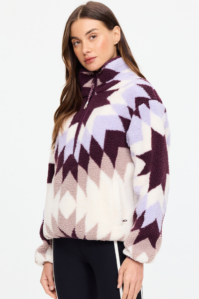 Three-quarter side angle of model Eden wearing the recycled shearling jacquard Harlow Fleece Pullover by The Upside in a geometric star motif.