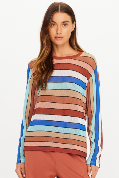 Three-quarter studio view of model Eden posing with her hand in her pocket wearing The Upside Iza Milla Long Sleeve Knit Top in Stripe.