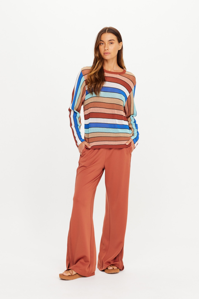 Three-quarter studio view of model Eden posing with her hand in her pocket wearing The Upside Iza Milla Long Sleeve Knit Top in Stripe.