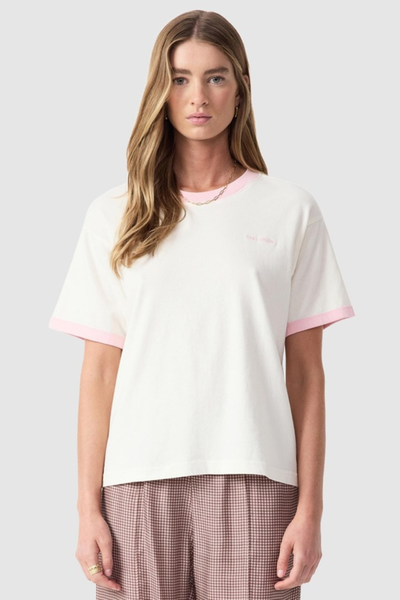 Studio front portrait of a model wearing the quartz organic cotton tee featuring pink ringer trim on the crew neckline and short sleeves.