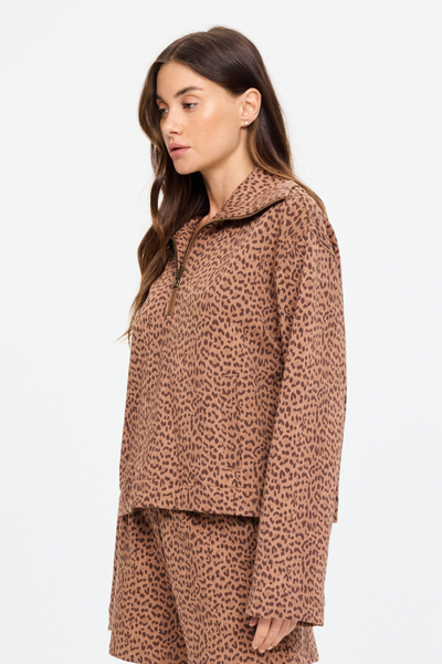 Side profile studio shot of the Javan Jones Quarter Zip Sweat in Javan leopard print. This angle showcases the relaxed silhouette, wide-cut sleeves, and dropped shoulder design of the organic cotton French terry fabric.