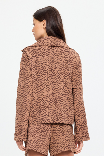 Rear view of a model wearing the matching leopard print sweater and shorts set. The shot highlights the clean back panel construction of the sweater and the drape of the wide collar.