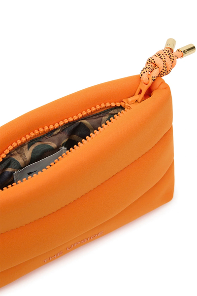 Close-up studio shot of the orange cushioned neoprene cosmetic pouch, highlighting the chunky zipper, neon paracord pull with metal aglets, and the visible La Paz palm print interior lining.
