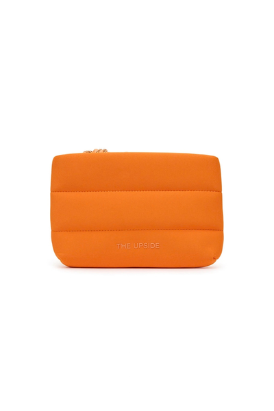 Flat product view of the bright orange cushioned neoprene cosmetic pouch against a clean white background, showing the quilted design and raised "The Upside" logo on the front.