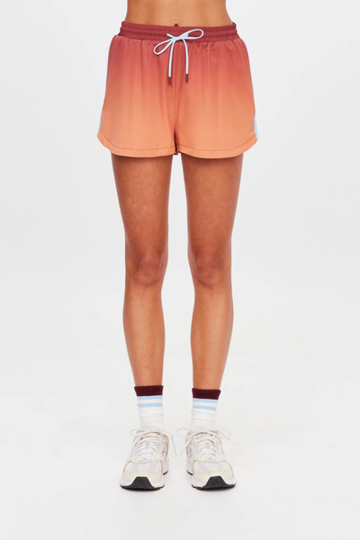 Studio front view from the waist down of a model wearing sunset ombre running shorts featuring light blue side seam tape and elastic drawstrings.