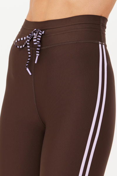 Close-up studio detail shot of the waistband of the Oxford Midi Pant. This view highlights the quality stitching of the high waistband, the textured, striped lilac drawstring, and the twin lilac stripes along the side seam.