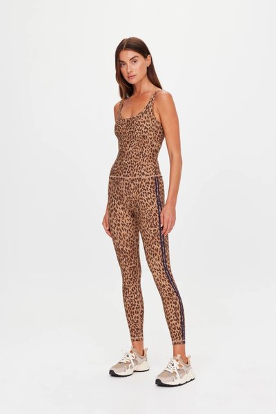 Full-length studio side view of a model wearing leopard print activewear midi leggings featuring contrast navy side stripes, styled with a matching tank top and sneakers.