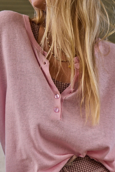 Close-up studio shot focusing on the neckline, pearlised pink buttons, and soft textured knit of the rosewater top.