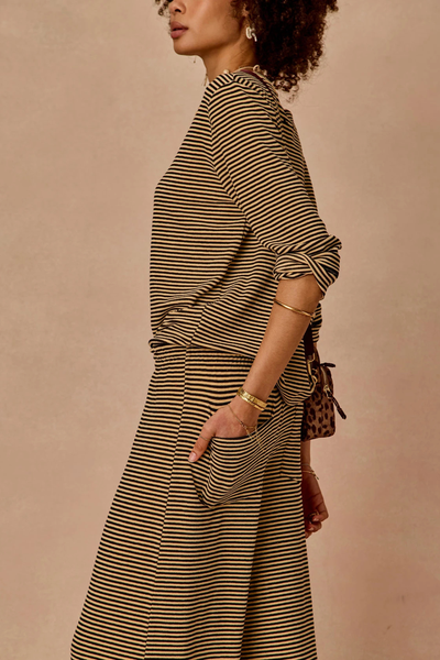 Close-up side view showcasing the back pocket and relaxed fit of the striped toweling pant.