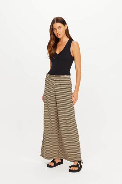 Full-body front studio view of a model wearing the Santos Adriel Split Pant paired with a black tank top and sandals.