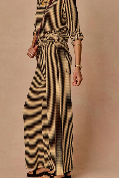 Side profile view of a model wearing the striped Santos Adriel Split Pant and matching top.