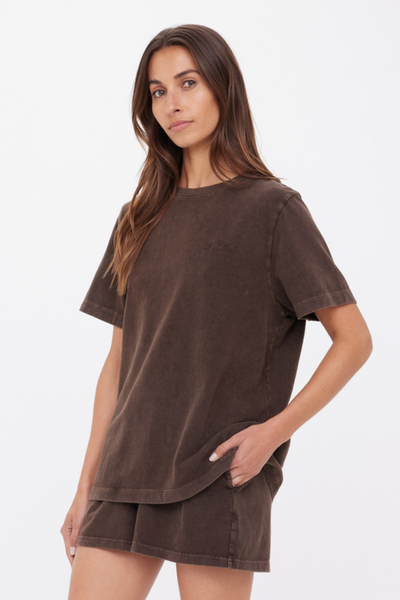 A rear view studio photograph capturing the back of the cocoa brown Soho Eva Crew Neck Tee, showcasing the clean yoke-free panels, the relaxed hang over the shoulders, and the matching set styling with shorts.