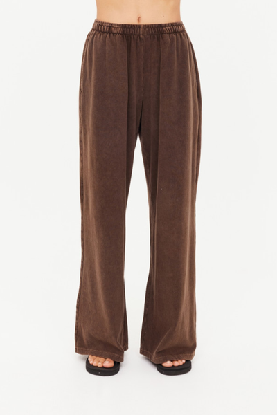 A front-on studio photograph from the waist down focusing on the relaxed fit of the dark brown Soho Tokio Wide Leg Pant, emphasizing the soft texture of the brushed recycled cotton fabrication and its fluid pool at the hem.