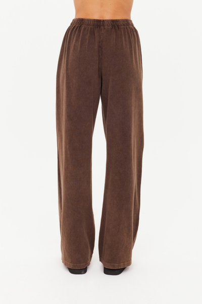 A full-length studio shot from the back showing the dark brown Soho Tokio Wide Leg Pant on a model, highlighting the high-waisted fit, relaxed pool over the heels, and clean rear silhouette.