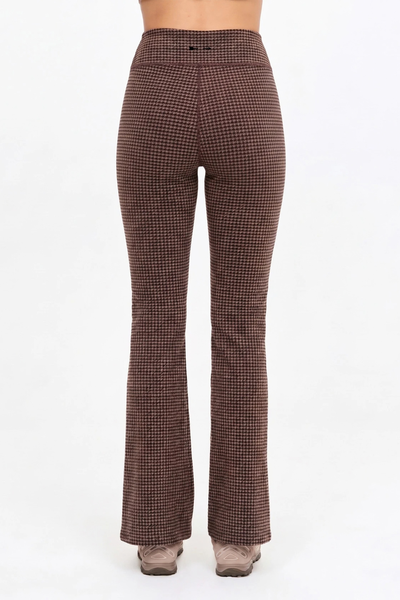 Studio rear view of a model wearing the geo check flare pants, highlighting the full-length silhouette and back waistband.