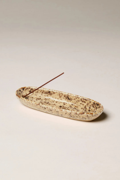 Studio product view of the Gentle Habits Collector Ceramic Incense Holder featuring a speckled leopard-pattern glaze holding an unlit incense stick against a plain background.