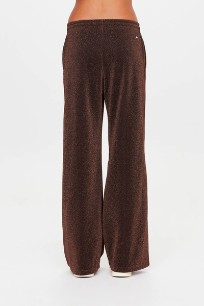 Rear studio view of the wide-leg pants, showing the clean silhouette and metallic sparkle fabrication.