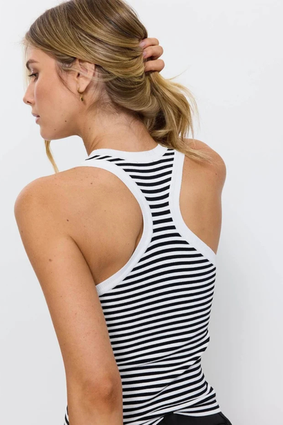 Close-up rear angle of a model wearing the Thrills Astra V Neck Tank in Black Stripe, highlighting the T-back racerback cut with white contrast rib binding.