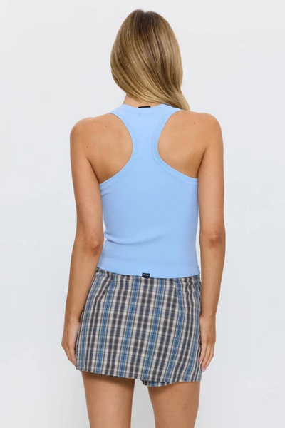 Full back view of a model wearing the Thrills Astra V Neck Tank in Placid Blue, showcasing the slim racerback cut and straight hemline with small brand tag.
