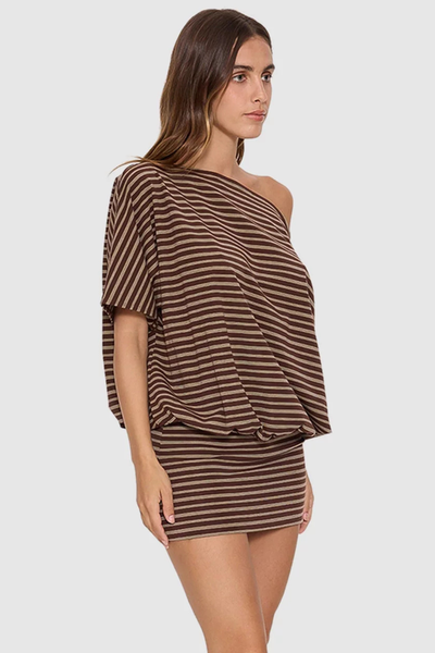 Three-quarter front view of a model wearing the Thrills Best Of Luck Demi Mini Dress in Cocoa, showcasing the brown striped knit pattern, asymmetrical one-shoulder silhouette, and blouson bodice.