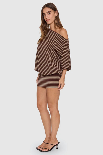 Full-length side profile view of model posing in the brown striped Thrills Best Of Luck Demi Mini Dress with black strappy kitten heel mules.