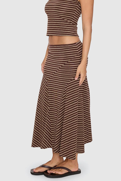 Side profile shot of model wearing the Thrills Best of Luck Sienna Midi Skirt in Cocoa showing the diagonal seam detailing and paneled striped pattern.