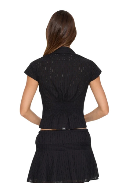 Back view of model wearing the black Thrills Danica Broderie Anglaise Top made from 100% cotton eyelet fabric with a fitted silhouette and smocked waist detailing.