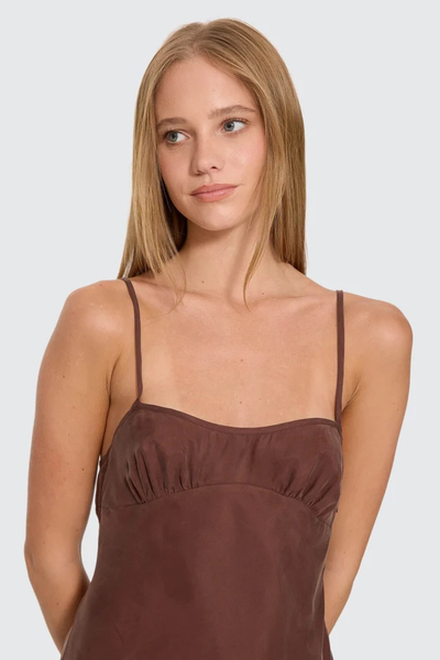 Close-up portrait view of model showcasing the straight neckline, gathered bust seam, and thin shoulder straps of the Thrills Elio Bias Mini Dress in Cocoa.