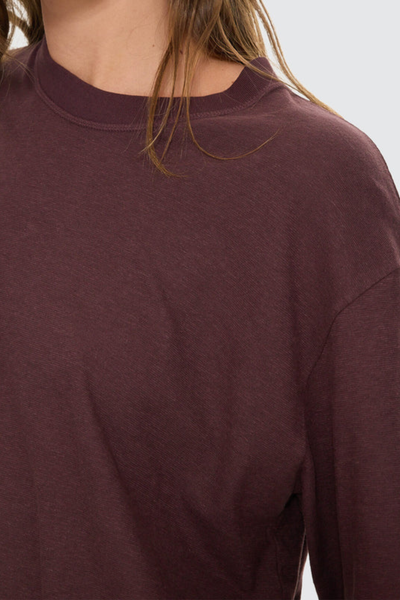 A closer image highlighting the tee's high-hip length, styled simply with relaxed washed denim to emphasize an effortless streetwear look.