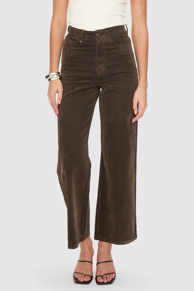 A side profile studio view on a model, emphasizing the smooth, tailored fit over the hips and the clean vertical hang of the wide-leg side seam.
